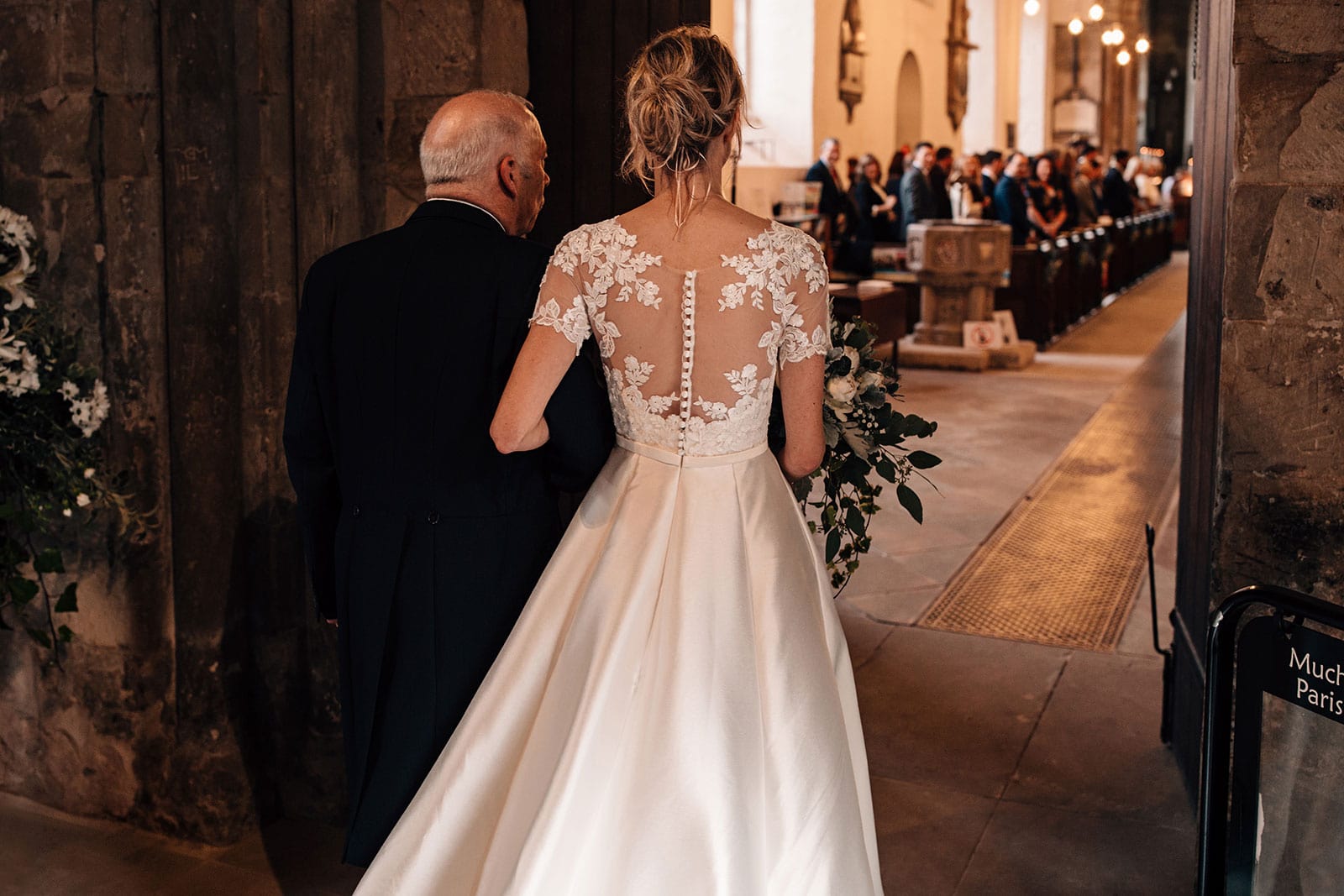 Documentary wedding photography of a bride and her father entering the church