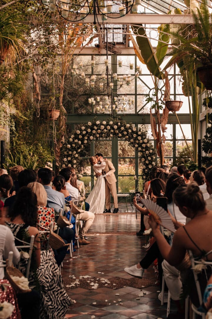 Bride and Groom at the end of the aisle in The Beldi Country Club greenhouse wedding venue, Marrakesh