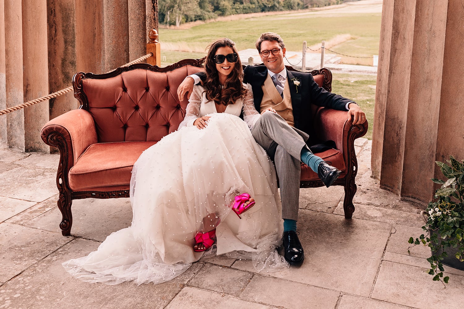 Rock and Roll stylish couple on their wedding day on a vintage chair wearing sunglasses