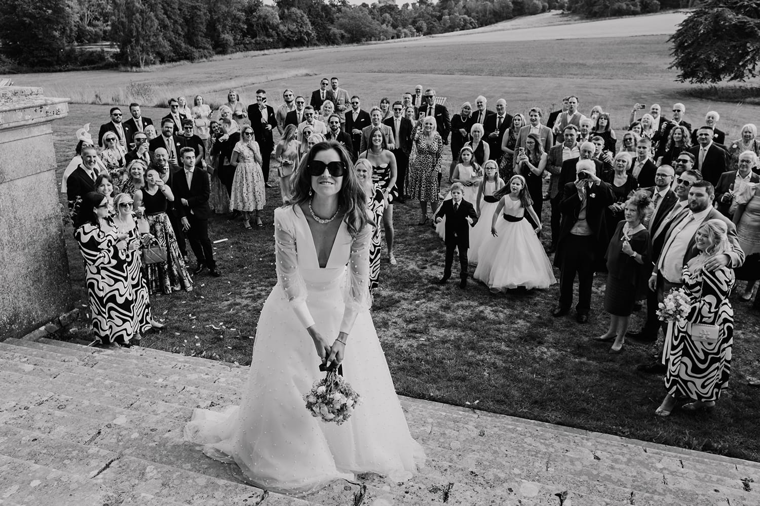 Black and white image of a Bride about to throw her bouquet