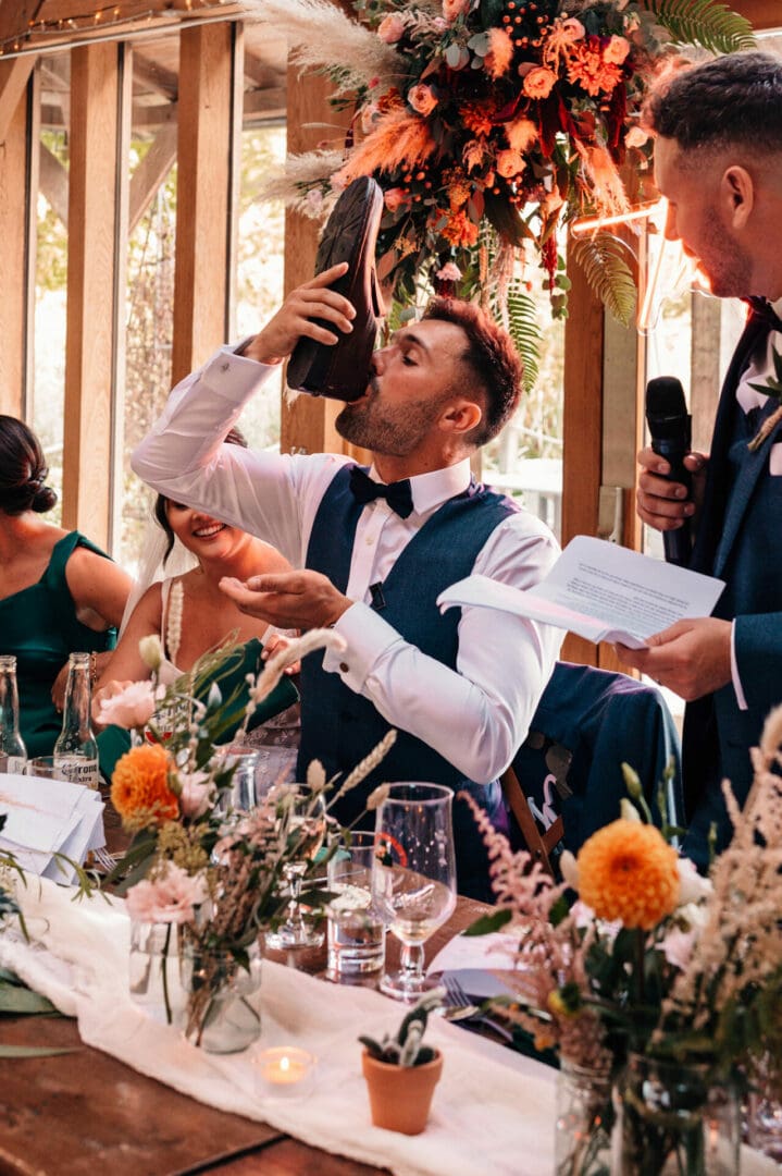 Groom drinking out of a shoe during a lively set of wedding speeches