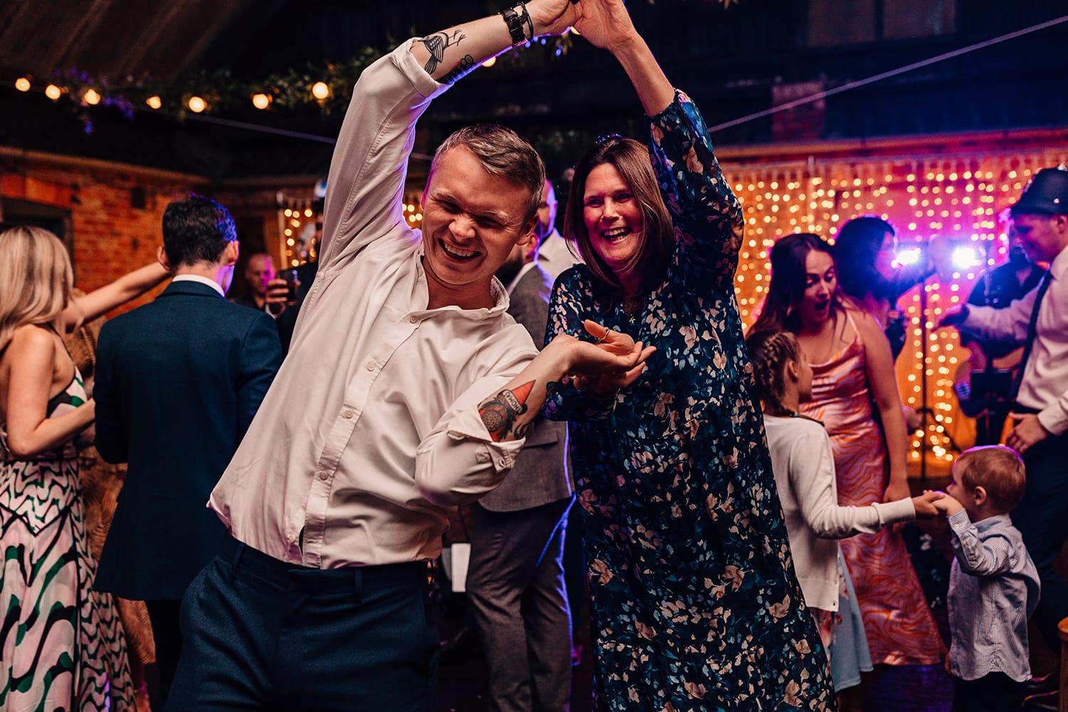 Fun photograph of wedding guests on the dance-floor spinning around