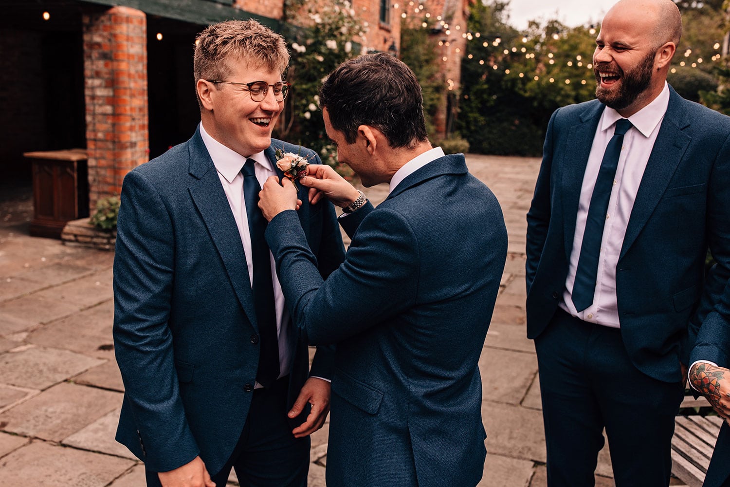 Grooms wedding preparations putting on buttonholes