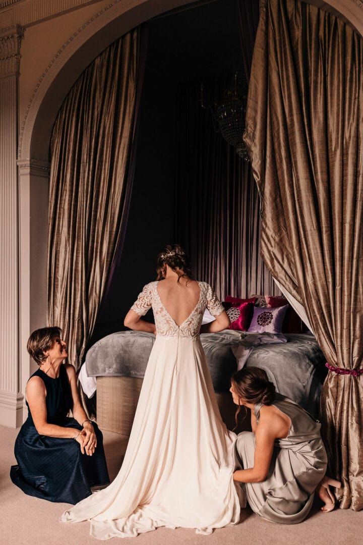 Bridal preparations, photograph of a bride getting into her wedding gown