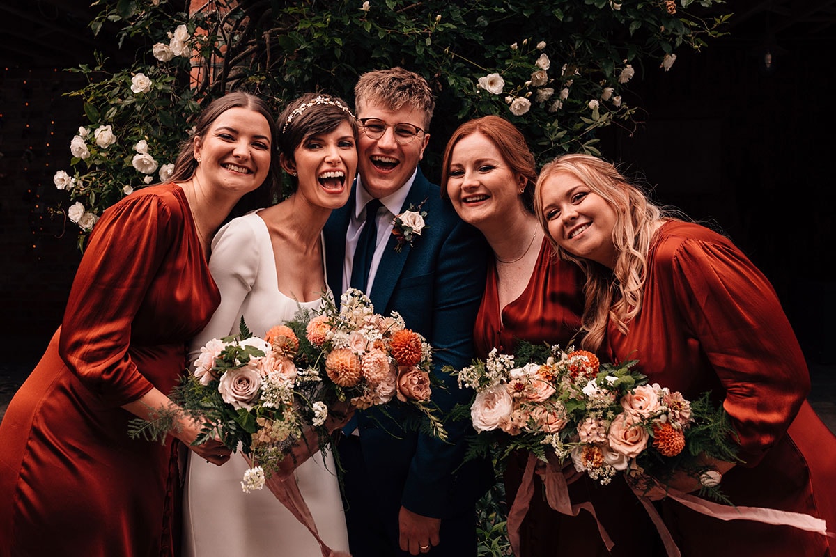 Natural group photograph of Bride and Groom with Bridesmaids