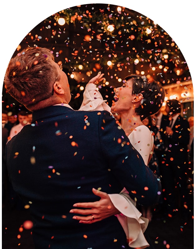 Newlywed couple dancing under a shower of confetti